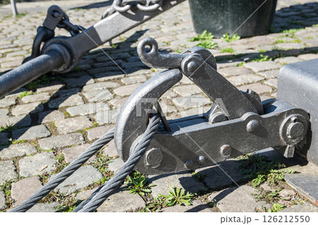 Fastening for anchor of the ship on a embankment in a port, near a river. Fastening for anchor of the ship on a embankment in a port, near a river. 126212550