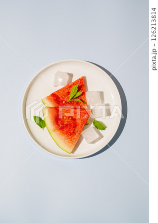 Watermelon triangle slices in a plate blue background Watermelon triangle slices in a plate blue background 126213814