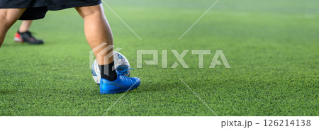 Soccer players in action on green grass field focusing on their legs and ball during game, showing movement and sports energy in close up view Soccer players in action on green grass field focusing on their legs and ball during game, showing movement and sports energy in close up view 126214138