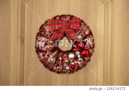 Decorated wreath with silver snowflakes, Christmas toys hangs on the door. Decorated wreath with silver snowflakes, Christmas toys hangs on the door. 126214172