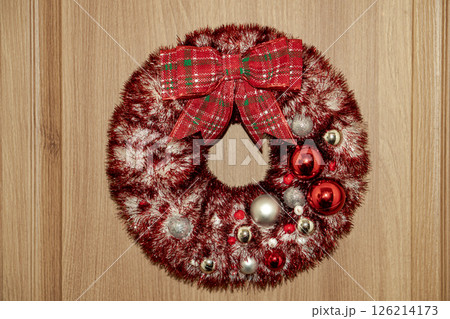 Decorated wreath with silver snowflakes, Christmas toys hangs on the door. Decorated wreath with silver snowflakes, Christmas toys hangs on the door. 126214173