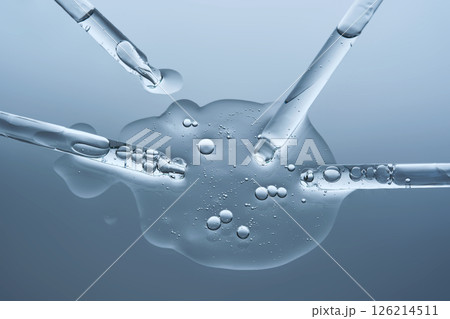 Facial serum and several pipettes on a blue background. The texture. Facial serum and several pipettes on a blue background. The texture. 126214511