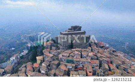Majestic medieval castle overlooking the serene village and rolling hills beneath a dusky sky in Italy Generative AI 126215212