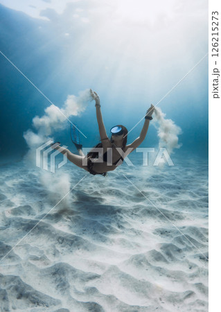 Freediver woman with sand underwater in blue sea. Beautiful sunlight with attractive woman. 126215273