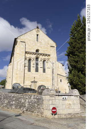 Saint Pierre Church rising above cemetery in La Sauve, France, under blue sky 126217183