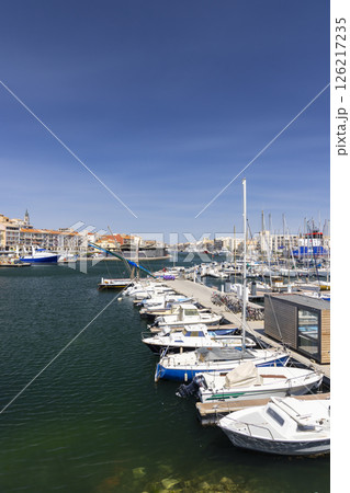Boats mooring at the Mole Saint Louis in Sete, France, under a clear blue sky Boats mooring at the Mole Saint Louis in Sete, France, under a clear blue sky 126217235