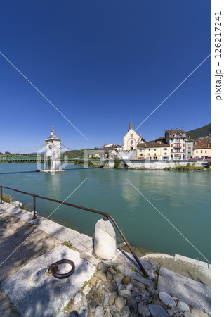 Seyssel suspension bridge over the Rhone river in France with church and blue sky 126217241