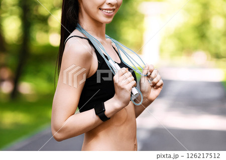 Fit Korean Girl In Sportswear Using Jump Rope For Workout Outdoors, Enjoying Training In Summer Park, Copy Space Fit Korean Girl In Sportswear Using Jump Rope For Workout Outdoors, Enjoying Training In Summer Park, Copy Space 126217512