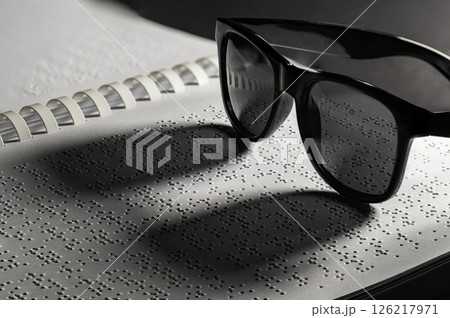 Homemade book. The Braille alphabets from A to Z in alphabetical order. Glasses on Braille written homemade book as concept for World Braille Day 126217971