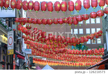 Beautiful of Red chinese lanterns hanging in rows above the street, strung between buildings. 126218573