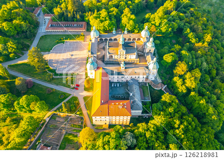 Set atop a hill, the baroque complex of Holy Mountain in Pribram is a significant pilgrimage site surrounded by lush greenery. Visitors admire the architecture and tranquil atmosphere. 126218981