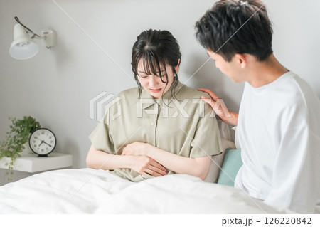 腹痛の女性と心配する男性(ベッドルーム・生理痛・つわり) 腹痛の女性と心配する男性(ベッドルーム・生理痛・つわり) 126220842