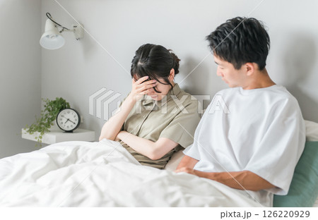 ベッドで体調不良の妻を心配する夫（頭痛・発熱・自律神経失調症） 126220929