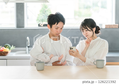 育児で困ってスマホで調べる若いアジア人夫婦 126221392