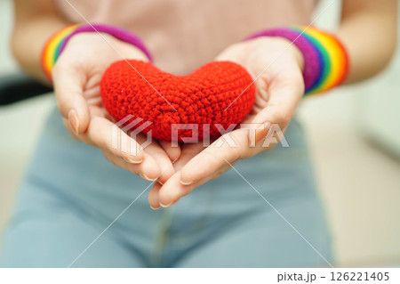 Asian woman holding LGBT heart with rainbow flag. 126221405