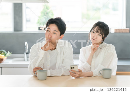 リビング・ダイニングで悩み・考える夫婦・カップル（悩む・回想・想像・将来・検討・計画） 126221413