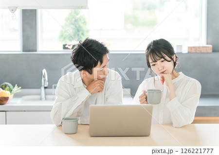 パソコンを見ながら家族会議をする夫婦・カップル（投資・貯金・資産運用・投資信託） 126221777