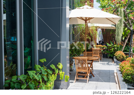 Outdoor wooden chairs and tables with parasols to relax at balcony Outdoor wooden chairs and tables with parasols to relax at balcony 126222164