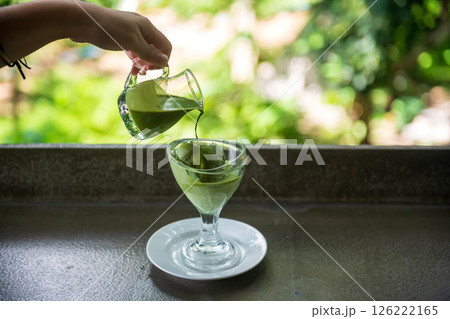 Affogato hot matcha green tea poured to ice cream in glass cup Affogato hot matcha green tea poured to ice cream in glass cup 126222165