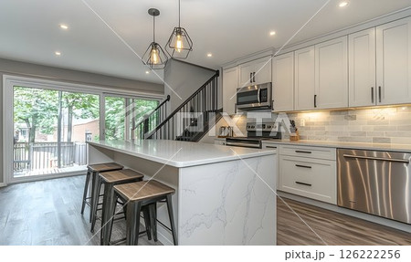 Modern Kitchen Interior with Island, Geometric Lights, and Stair 126222256