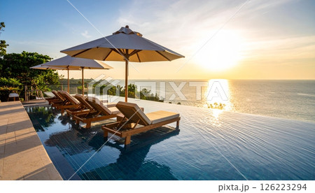 Luxurious infinity pool with sun loungers and umbrella 126223294