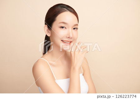 A beautiful young Asian woman with clean, fresh skin against a beige background. Skincare, facial treatment, cosmetology, beauty, and spa. An elegant portrait of an Asian woman. A beautiful young Asian woman with clean, fresh skin against a beige background. Skincare, facial treatment, cosmetology, beauty, and spa. An elegant portrait of an Asian woman. 126223774