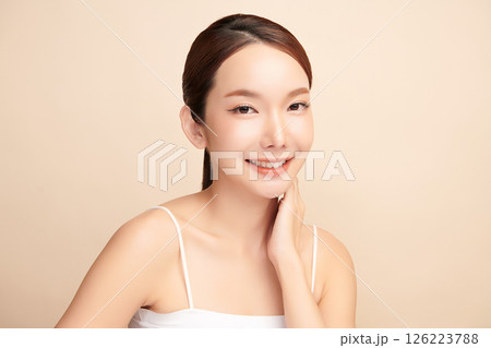 A beautiful young Asian woman with clean, fresh skin against a beige background. Skincare, facial treatment, cosmetology, beauty, and spa. An elegant portrait of an Asian woman. A beautiful young Asian woman with clean, fresh skin against a beige background. Skincare, facial treatment, cosmetology, beauty, and spa. An elegant portrait of an Asian woman. 126223788
