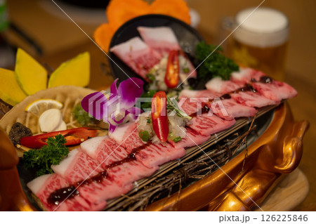 Japanese style sliced beef prepared on the plate, with flower decoration Japanese style sliced beef prepared on the plate, with flower decoration 126225846