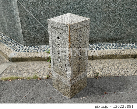 枚方宿高札場跡と万年寺山の方向を示す石の道しるべがある風景　大阪府枚方市三矢町 126225881