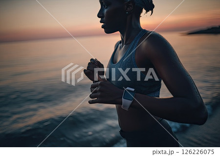 Portrait of a young woman running on the beach during sunset. With the sun setting behind her, the woman joyfully runs on the beach, a symbol of freedom and vitality. 126226075
