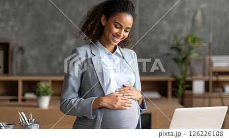 Young pregnant Asian woman in front of laptop monitor at home. The pregnant woman beams with joy during her video call with the doctor, preparing for motherhood. Young pregnant Asian woman in front of laptop monitor at home. The pregnant woman beams with joy during her video call with the doctor, preparing for motherhood. 126226188
