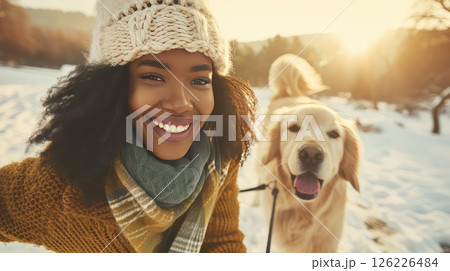 Young African American woman having fun while strolling with her best friend - golden retriever dog. A beautiful bond between a woman and her golden companion, walking hand in paw. Young African American woman having fun while strolling with her best friend - golden retriever dog. A beautiful bond between a woman and her golden companion, walking hand in paw. 126226484