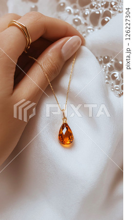 A detailed artistic close-up of a hand adorned with gold jewelry amidst a bubble-laden surface, emphasizing elegance and softness with a luxurious feel. Jewelry, lifestyle, and beauty themes. 126227304