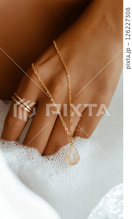 A detailed artistic close-up of a hand adorned with gold jewelry amidst a bubble-laden surface, emphasizing elegance and softness with a luxurious feel. Jewelry, lifestyle, and beauty themes. 126227308