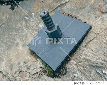 Plate and anchor bolt. Structural support on natural stone with gap to plate and anchor bolt in rocky base Plate and anchor bolt. Structural support on natural stone with gap to plate and anchor bolt in rocky base 126227433