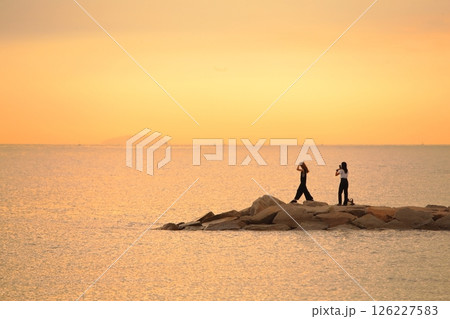 夕方の海で遊ぶ女性 126227583