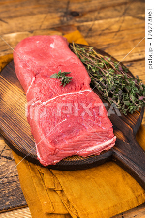 Fresh raw bison meat displayed on a wooden board, showcasing its rich red color and tenderness, ideal for gourmet cooking adventures. wooden background. top view 126228061