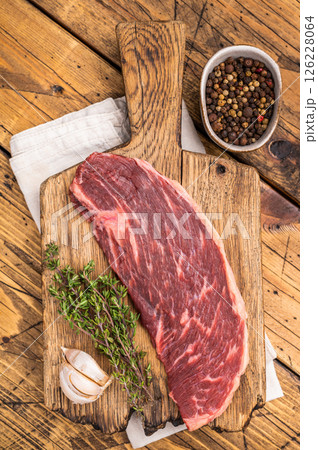Raw rump cap steak, uncooked beef meat, showcasing its rich marbling and vibrant color. wooden background. top view 126228064