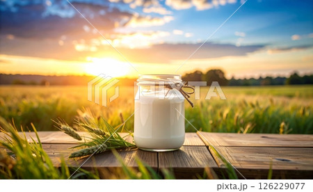 Milk in glass bottle on wooden table at sunset Milk in glass bottle on wooden table at sunset 126229077