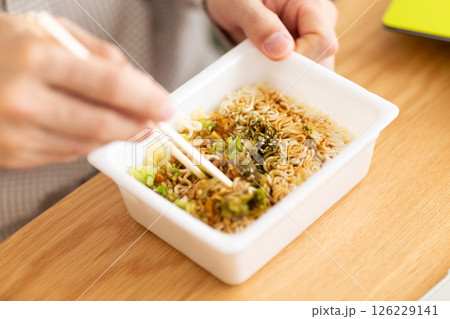 カップ焼きそばを作るミドル男性の手元 126229141