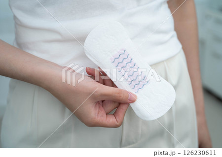 Asian woman holding sanitary napkin pad for hygiene menstrual period cycle protection. 126230611