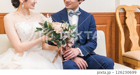 結婚式場のブライズルーム・控室で花束・ブーケを持つ新郎新婦の男女(ドレス試着・衣装合わせ) 126230699