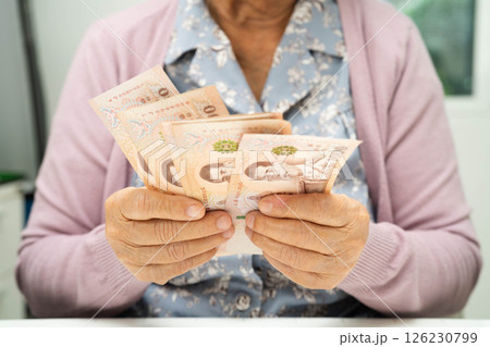 Retired elderly woman counting coins money and worry about monthly expenses and treatment fee payment. Retired elderly woman counting coins money and worry about monthly expenses and treatment fee payment. 126230799