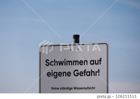 A sign in German with the words "Schwimmmen auf eigene Gefahr" written on it 126231513