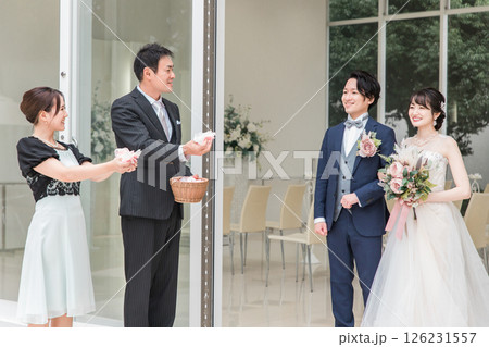 結婚式でフラワーシャワーを浴びる新郎新婦と祝うゲスト 126231557