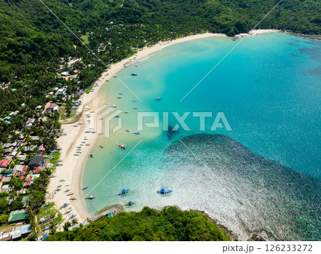 Fishing boats over turquoise water and white sands with sun reflection. Diapela Beach. El Nido, Philippines. Fishing boats over turquoise water and white sands with sun reflection. Diapela Beach. El Nido, Philippines. 126233272