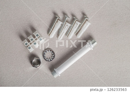Fixing ceiling chandelier dowels and washers on gray background, close-up Fixing ceiling chandelier dowels and washers on gray background, close-up 126233563