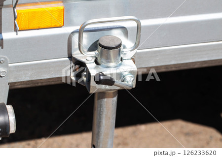 orange reflector on the side of a galvanized trailer body, close-up 126233620