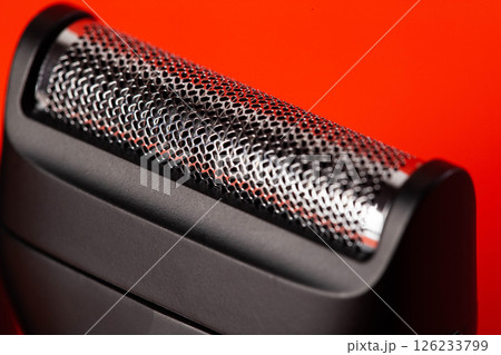 Modern shaving head on a red background. Beard care, close-up 126233799