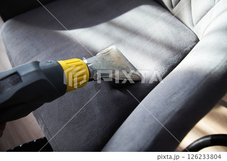 Services for washing and cleaning upholstered furniture with a vacuum cleaner. Cleaning dirty gray chairs in the apartment, industry Services for washing and cleaning upholstered furniture with a vacuum cleaner. Cleaning dirty gray chairs in the apartment, industry 126233804